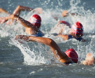Competitors swimming out into open water at the beginning of tri